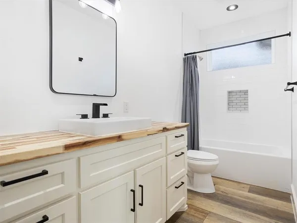 an empty room with ceiling fan and windows