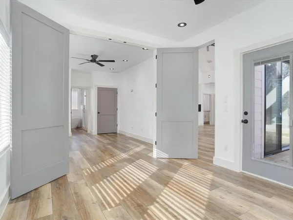 a view of an empty room with a window and wooden floor