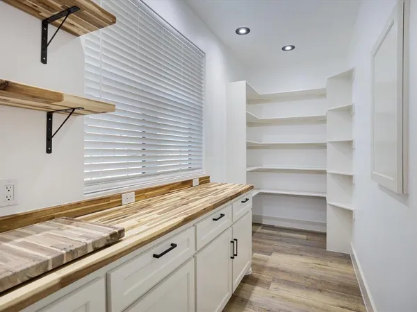 a kitchen with white cabinets and a window