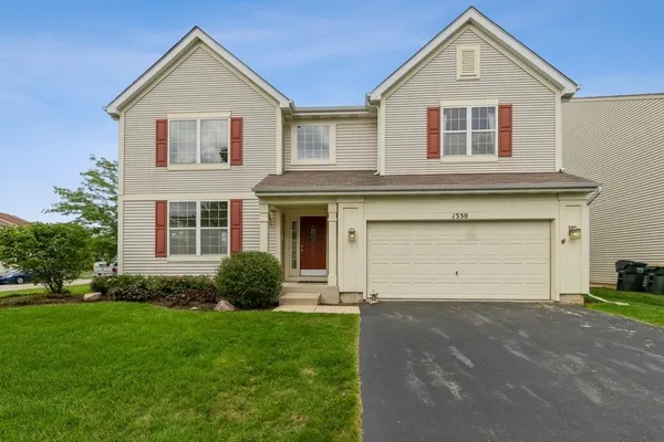 a front view of a house with a yard and garage