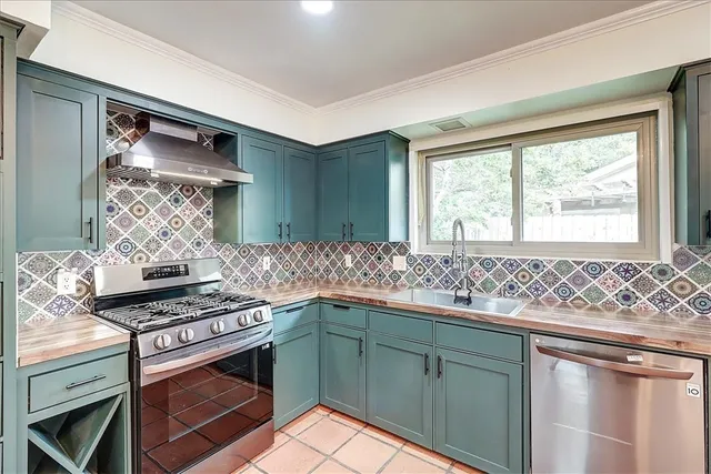 a kitchen with stainless steel appliances granite countertop a sink stove and cabinets