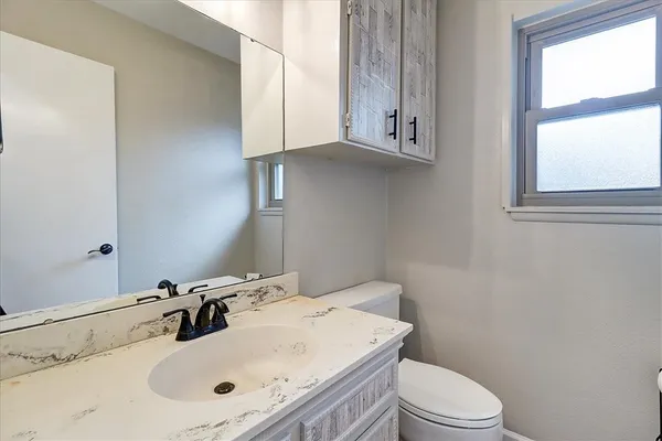 a bathroom with a sink toilet and mirror