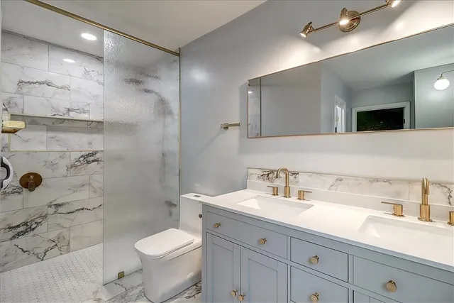 a bathroom with a sink a toilet and shower