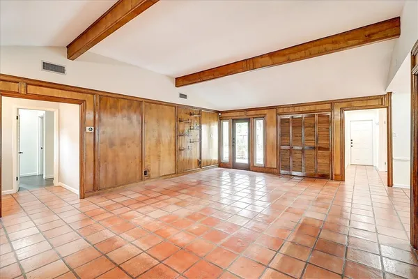 a view of an empty room with window and a livingroom