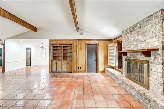a view of a hallway with wooden floor and a fireplace