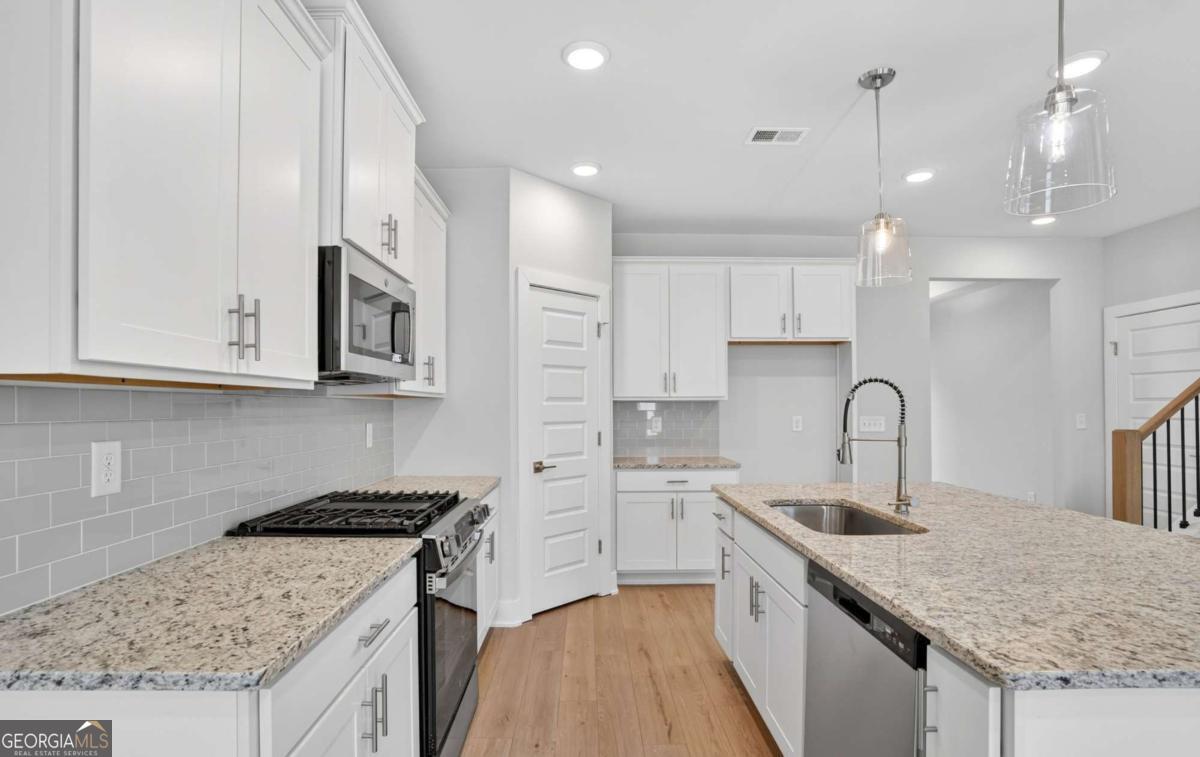 136 Patillo Manor, Unit 9 Stockbridge, GA 30281 - Photo 13 of 18 a kitchen with granite countertop a sink a stove and cabinets