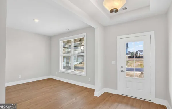 an empty room with wooden floor and windows