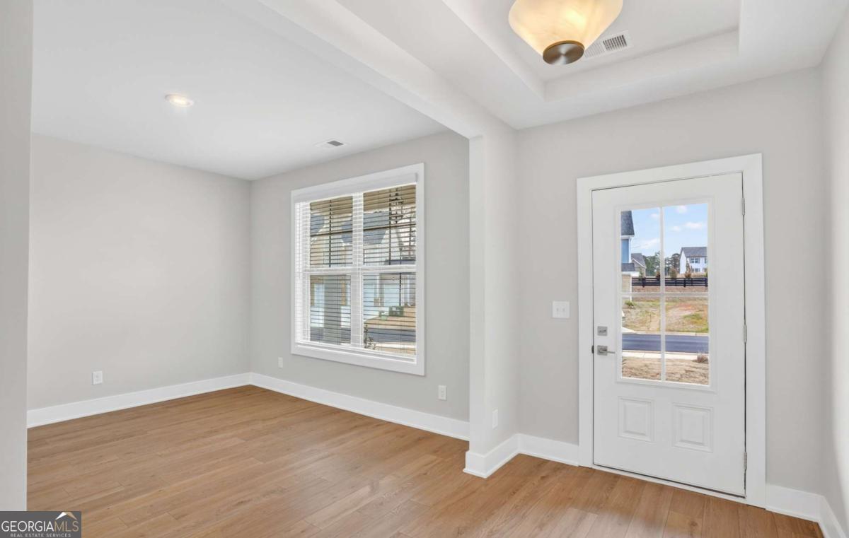 136 Patillo Manor, Unit 9 Stockbridge, GA 30281 - Photo 5 of 18 an empty room with wooden floor and windows