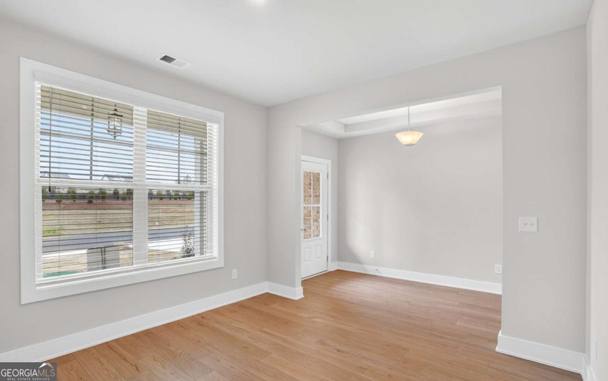 136 Patillo Manor, Unit 9 Stockbridge, GA 30281 - Photo 7 of 18 a view of an empty room with wooden floor and a window