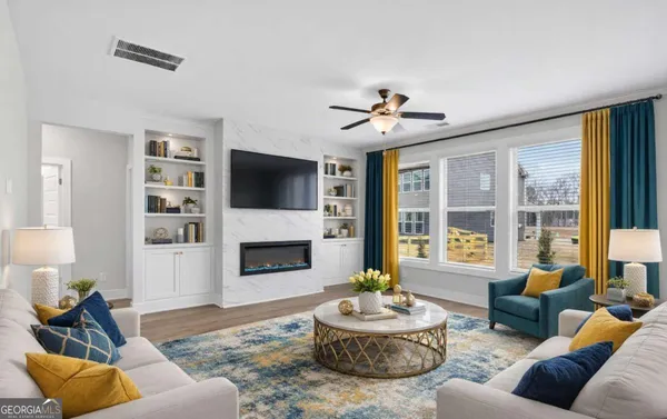 a living room with furniture a fireplace and a large window