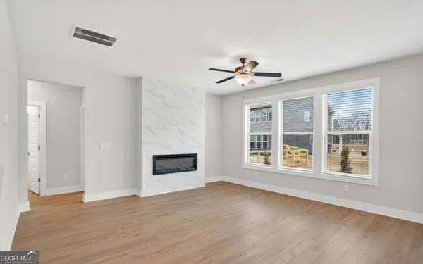 a view of an empty room with a window and fireplace