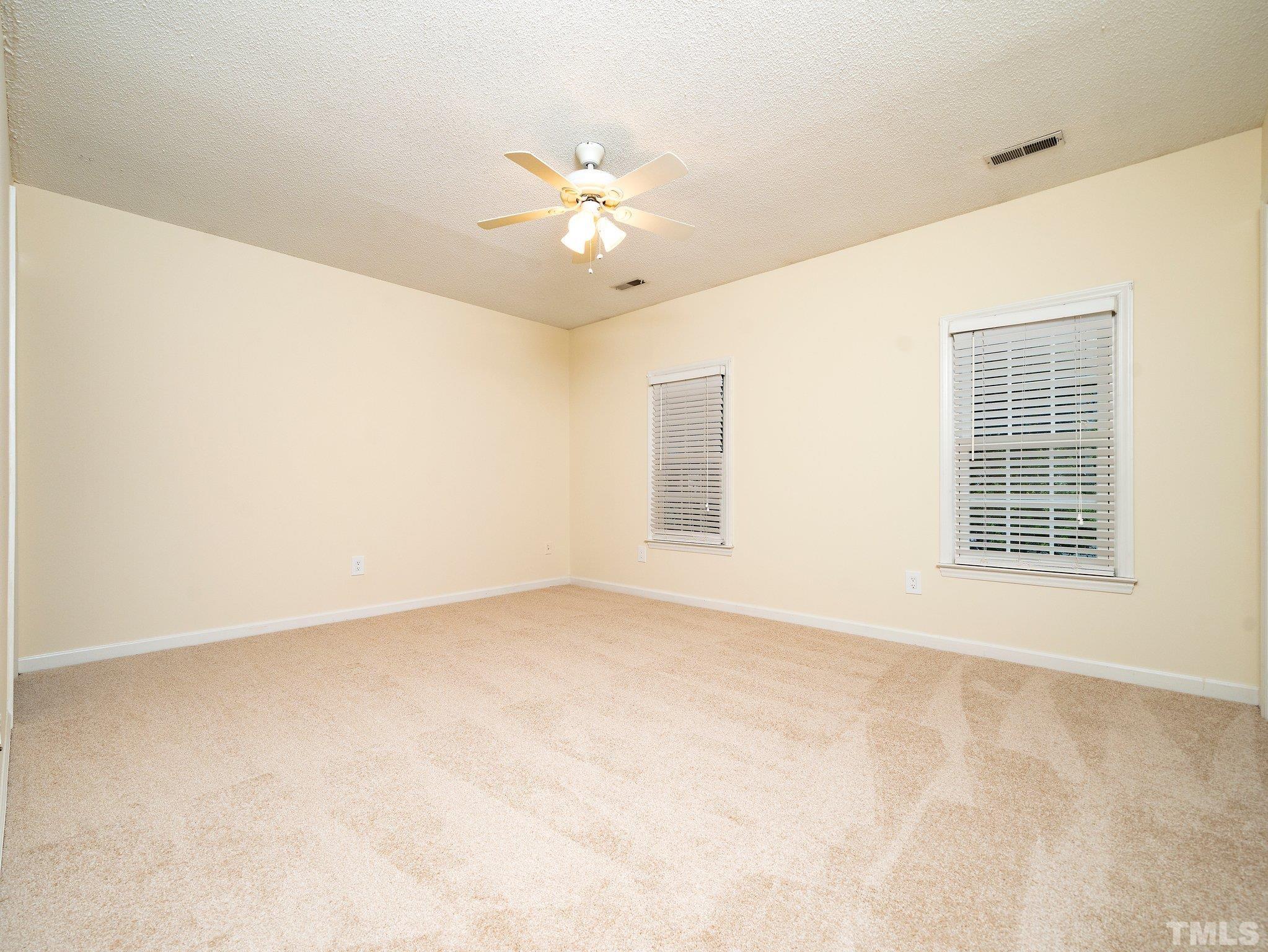 5632 Bridgetowne Way Raleigh, NC 27609 - Photo 16 of 26 an empty room with windows and chandelier fan