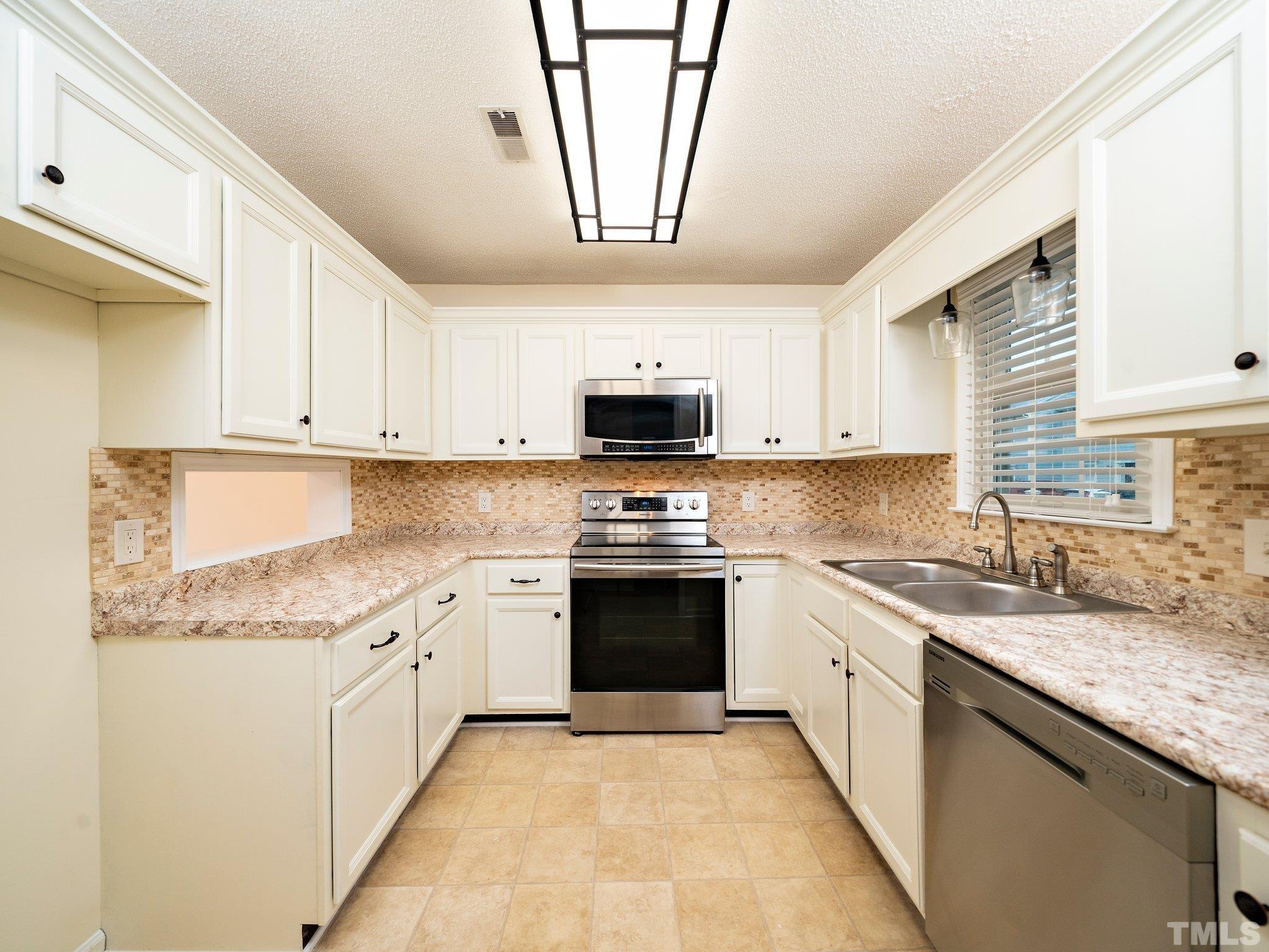 5632 Bridgetowne Way Raleigh, NC 27609 - Photo 3 of 26 a kitchen with granite countertop a sink stainless steel appliances and cabinets