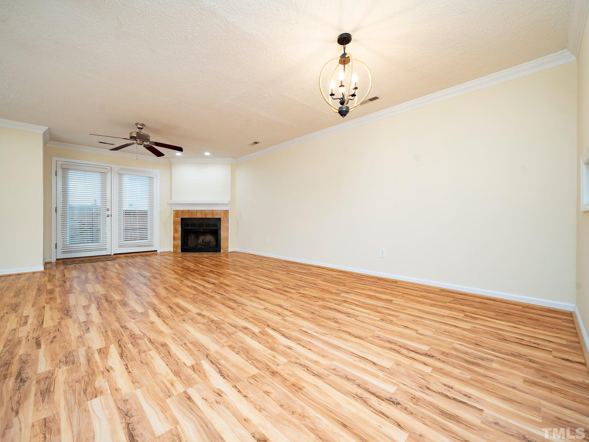 5632 Bridgetowne Way Raleigh, NC 27609 - Photo 7 of 26 a view of empty room with wooden floor and fireplace