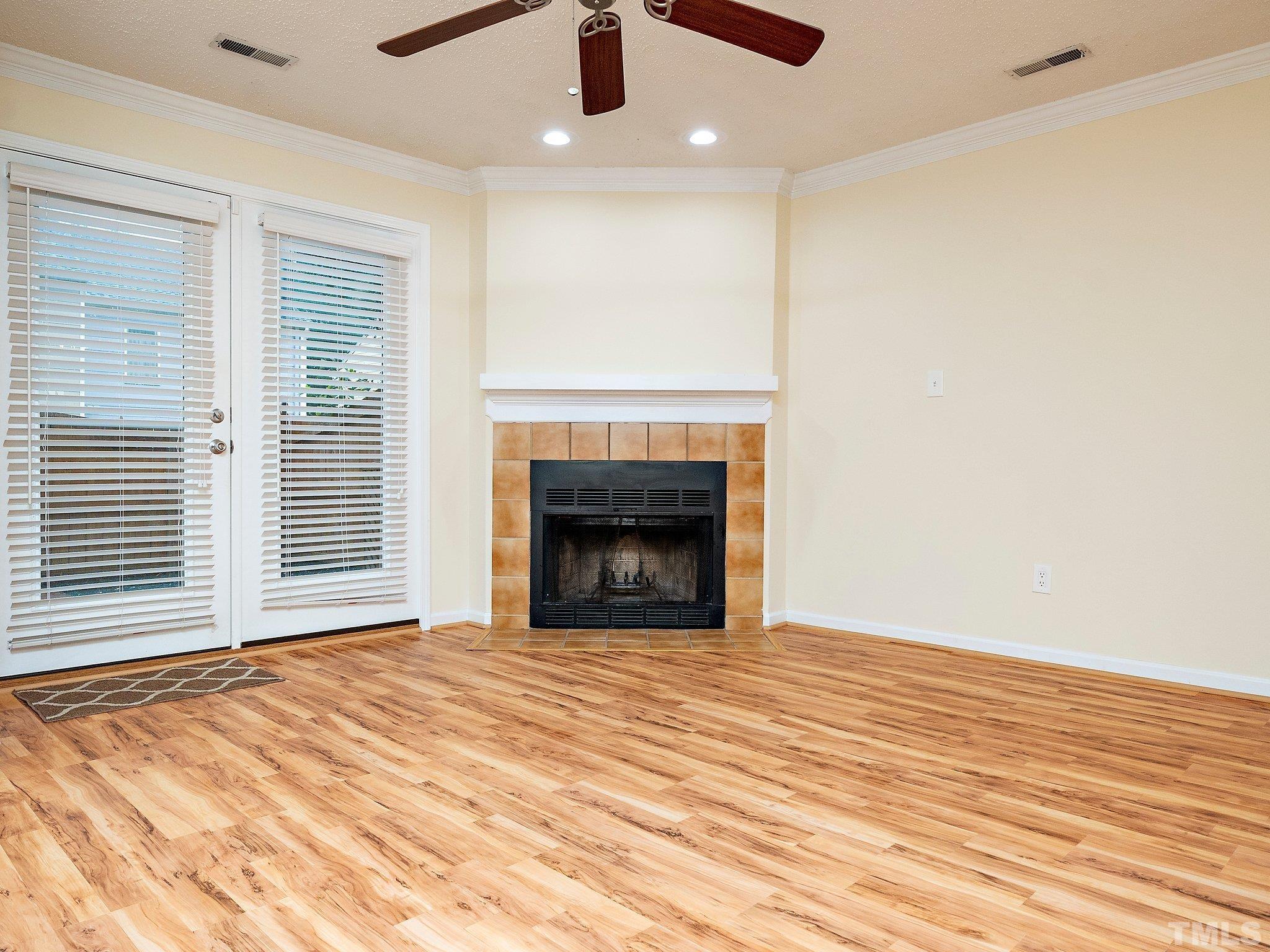 5632 Bridgetowne Way Raleigh, NC 27609 - Photo 10 of 26 a view of an empty room with wooden floor fireplace and a window