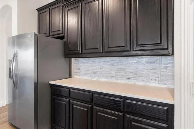 a kitchen with a refrigerator and cabinets