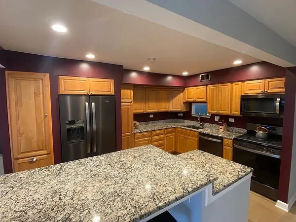a kitchen with stainless steel appliances granite countertop a sink stove and refrigerator