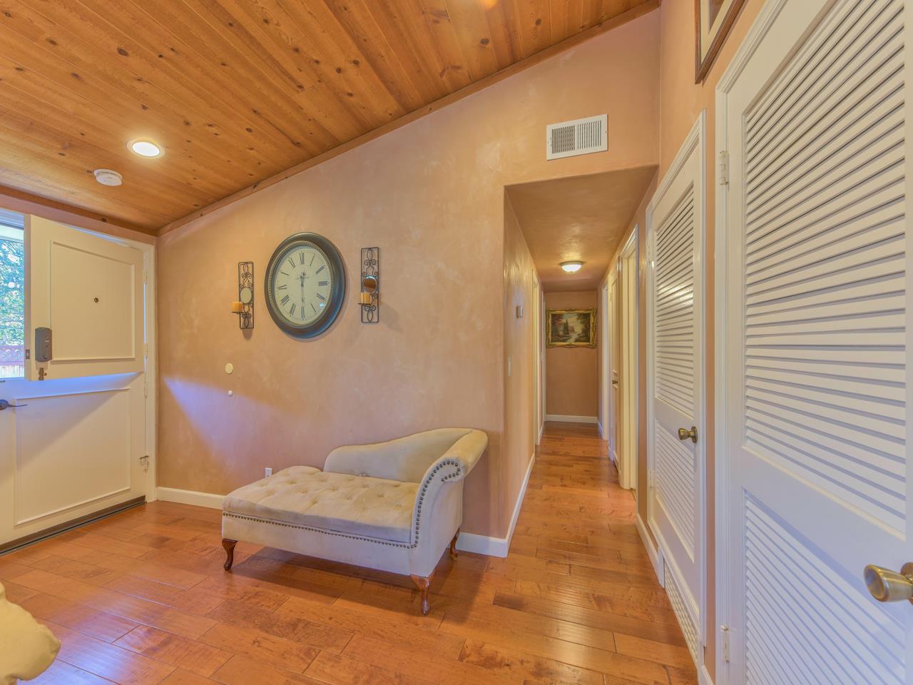 26464 Mission Fields Road Carmel, CA 93923 - Photo 21 of 35 a hallway with a large mirror on a dresser with wooden floor