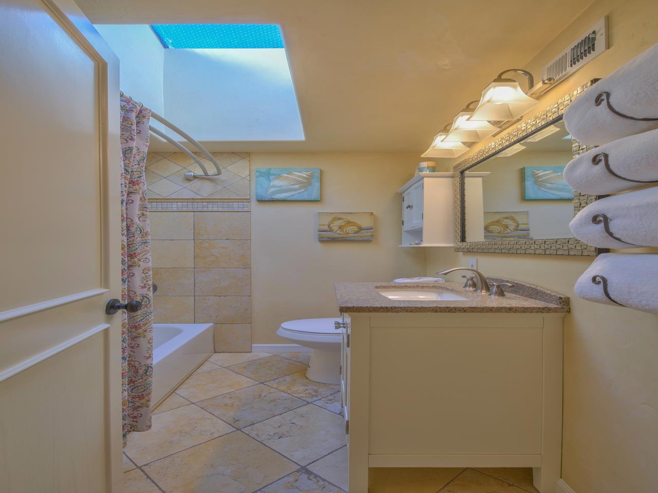 26464 Mission Fields Road Carmel, CA 93923 - Photo 29 of 35 a bathroom with a granite countertop sink a toilet and a mirror