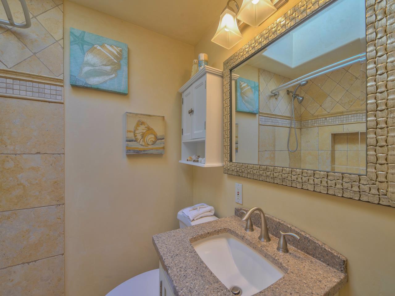 26464 Mission Fields Road Carmel, CA 93923 - Photo 30 of 35 a bathroom with a granite countertop sink a mirror and a shower