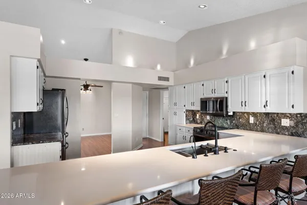 a bathroom with a granite countertop sink a toilet and shower