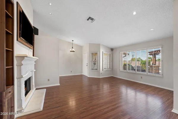 a view of a room with wooden floor ceiling fan and window