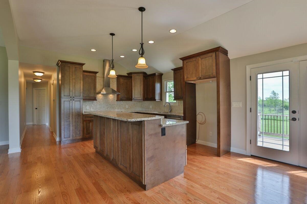 12665 Stateline Road Cedar Lake, IN 46303 - Photo 4 of 10 a kitchen with stainless steel appliances granite countertop wooden floors wooden cabinets a sink and a refrigerator