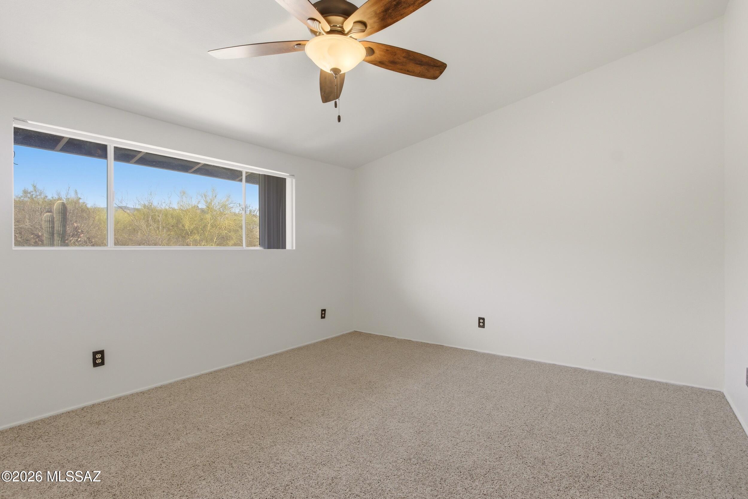 9141 East Indian Canyon Road Tucson, AZ 85749 - Photo 16 of 33 an empty room with a window and a ceiling fan