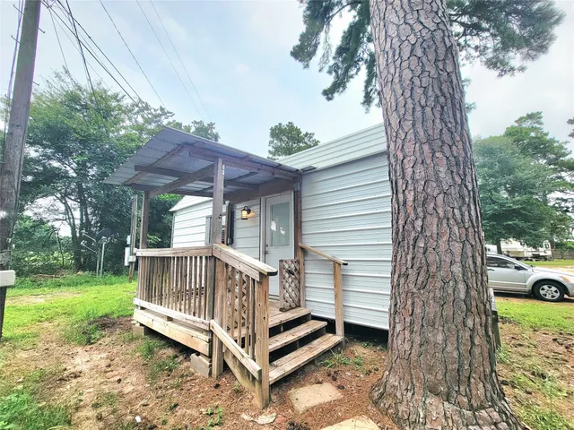 a view of a wooden deck with a bench and a yard
