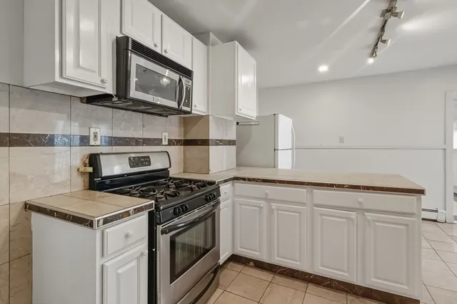 a kitchen with granite countertop cabinets stainless steel appliances and a sink