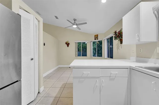 a view of a kitchen with a sink and dishwasher with white cabinets