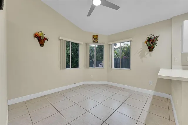 a view of an empty room with a window and cabinet area