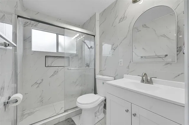 a bathroom with a sink toilet and shower