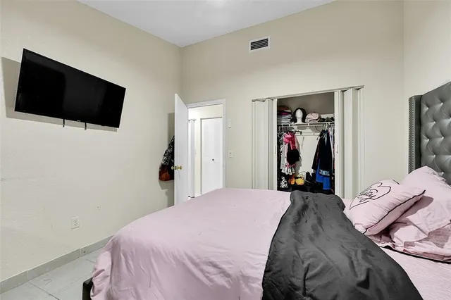 a bedroom with a bed and a flat tv screen