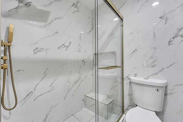 a bathroom with a toilet and a shower