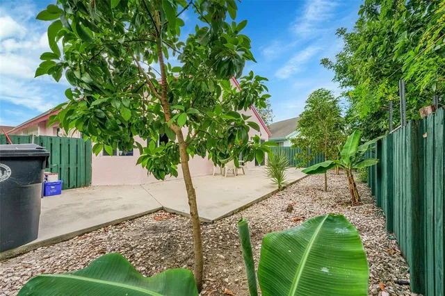 a view of backyard with table and chairs and wooden fence