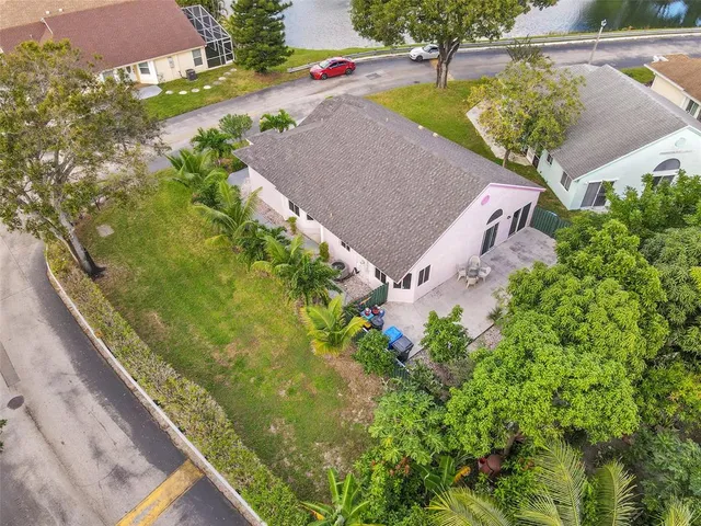 an aerial view of a house with outdoor space and a lake view in back