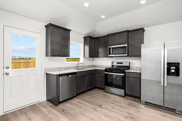 a kitchen with granite countertop stainless steel appliances and wooden cabinets