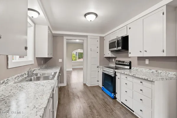a view of an empty room with a cabinet and mirrors