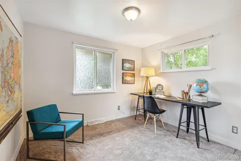 a view of a workspace with furniture and a window