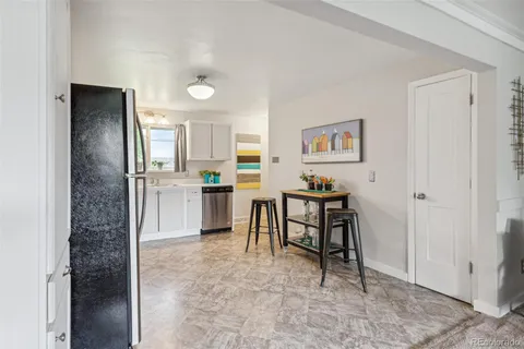 a open kitchen with kitchen island a refrigerator stove a sink and a dining table