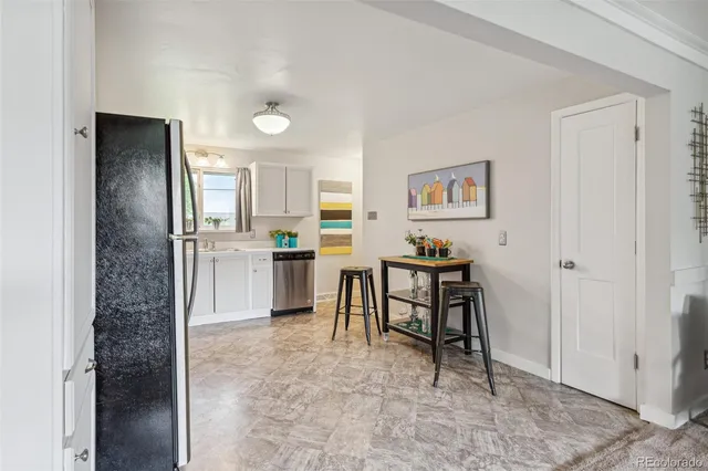 a open kitchen with kitchen island a refrigerator stove a sink and a dining table