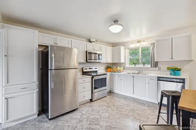 a kitchen with white cabinets and stainless steel appliances