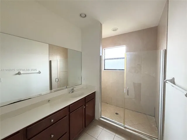 a bathroom with a double vanity sink mirror and shower