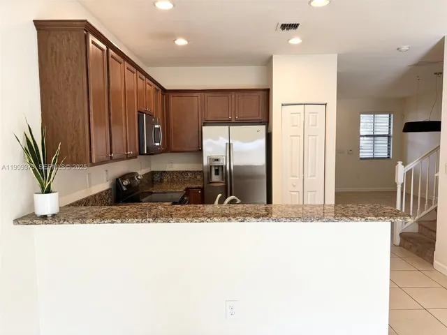 a view of a kitchen with a sink a refrigerator and a stove
