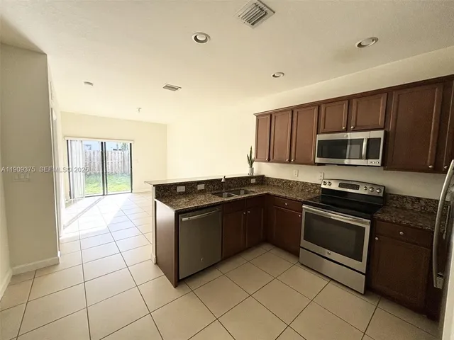 a kitchen with stainless steel appliances granite countertop a stove a microwave and a sink