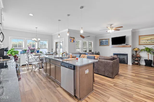 a kitchen with granite countertop a stove a sink a dining table and chairs