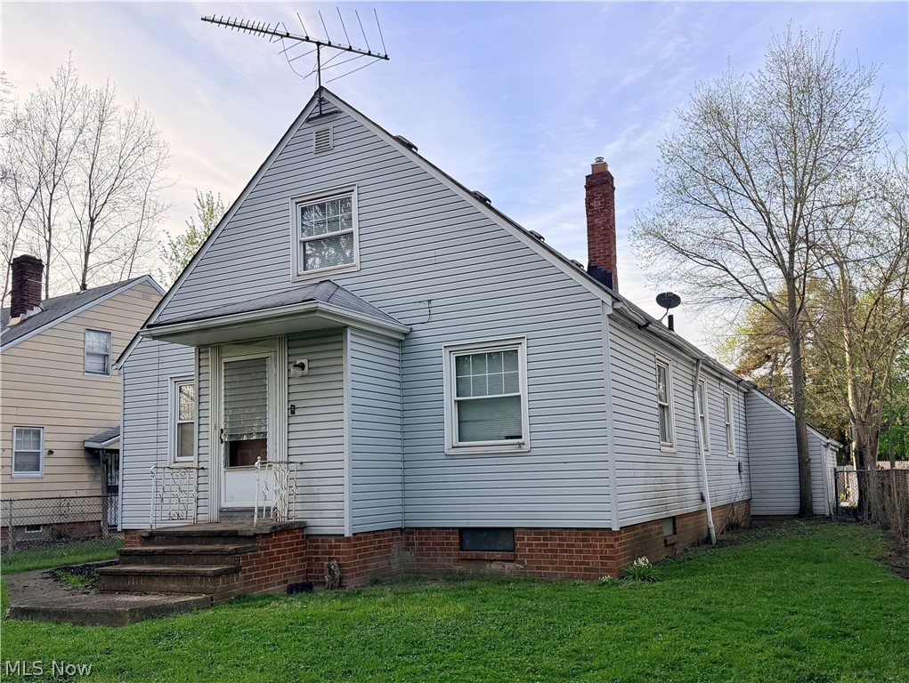 10506 Park Heights Road Cleveland, OH 44104 - Photo 5 of 22 Light blue siding with a gable roof and brick foundation