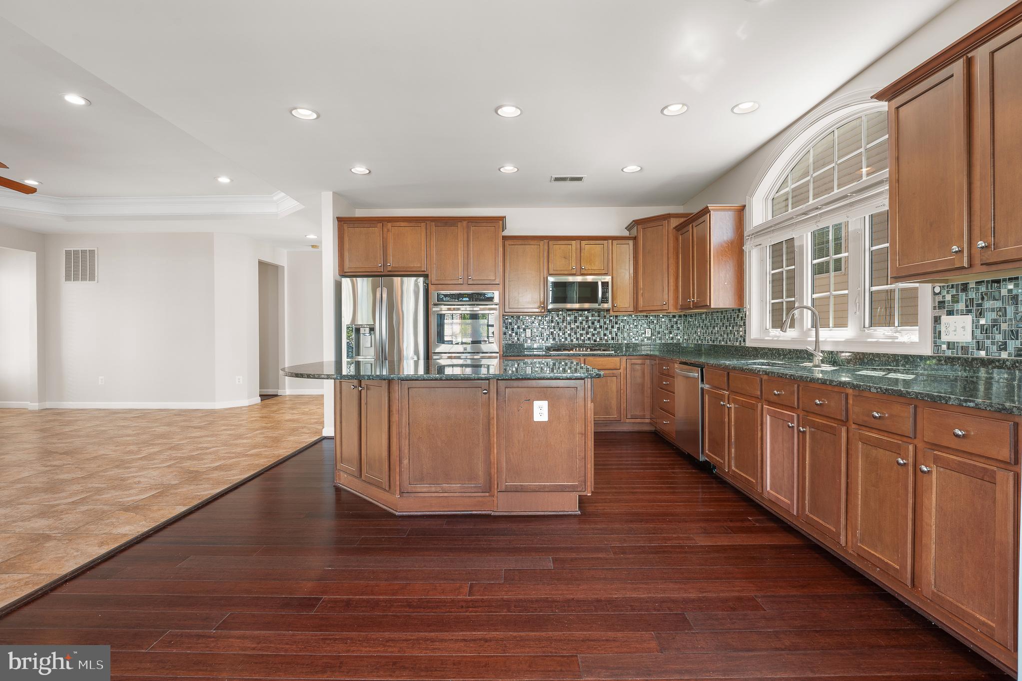 16862 Reef Knot Way Woodbridge, VA 22191 - Photo 21 of 99 a large kitchen with stainless steel appliances granite countertop a large counter top a sink and a wooden floors