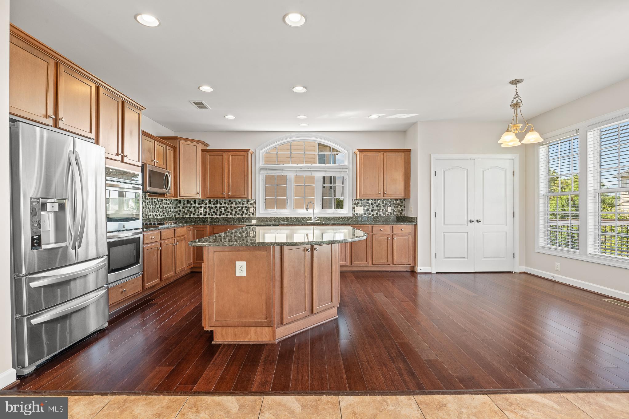 16862 Reef Knot Way Woodbridge, VA 22191 - Photo 23 of 99 a kitchen with stainless steel appliances granite countertop a refrigerator a sink dishwasher a stove and white cabinets with wooden floor
